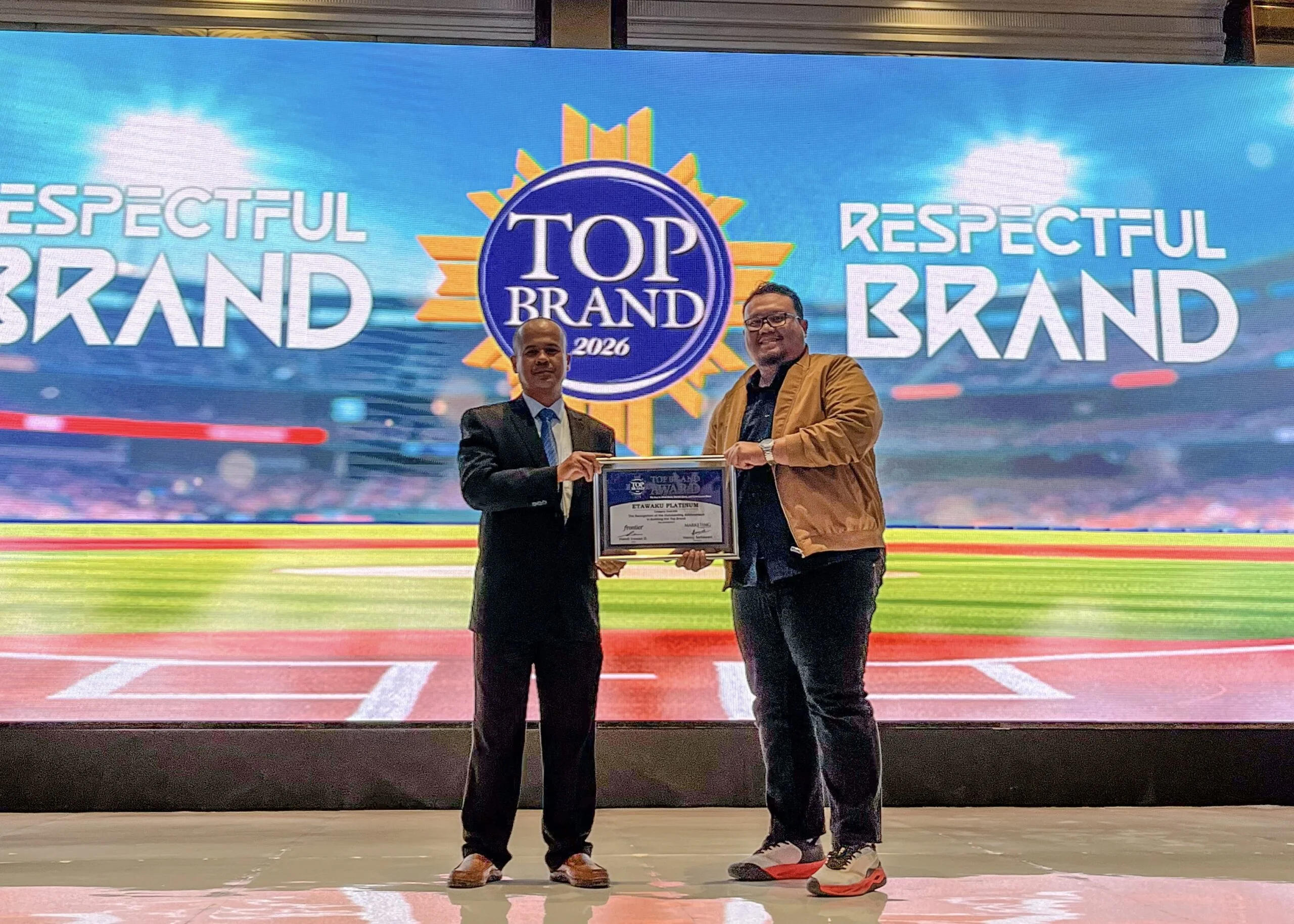Bapak Fakhara Agam selaku Direktur Merchandiser Bumi Wijaya Strategic Holding menerima penghargaan Top Brand 2026 untuk produk Etawaku Platinum dalam kategori Susu Kambing.