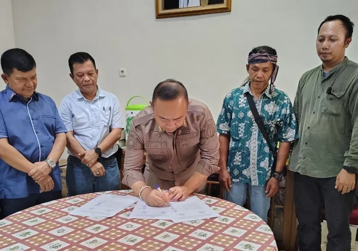 DAMAI - Bupati Ketapang Alexander Wilyo saat menteken kesepakatan damai antara Temanggong Adat Dusun Lelayang dengan PT Mayawanan Persada.