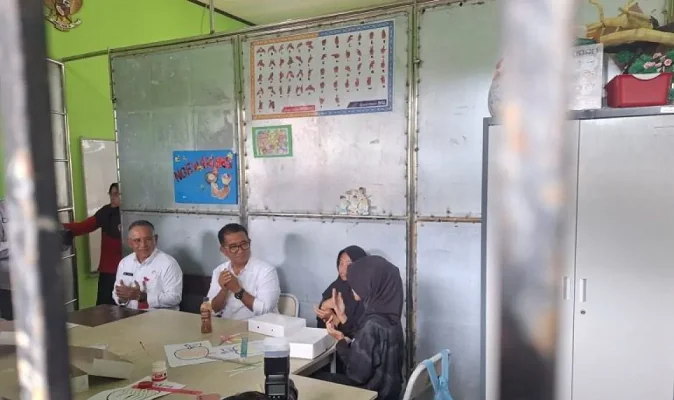 Pj Gubernur Kaltim Akmal Malik mencontohkan kepada dua siswi SLBN Balikpapan untuk terlebih dahulu membaca doa sebelum menikmati santapan menu makan bergizi gratis. (ANTARA)