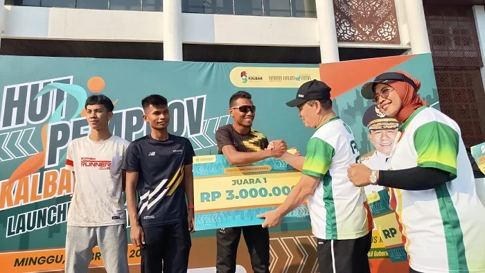 HADIAH - Gubernur Kalimantan Barat Ria Norsan beserta istri Erlina saat menyerahkan hadiah kepada para pemenang Akcaya Run 2026 di Halaman Kantor Gubernur Kalimantan barat, Minggu (1/2/2026) Kegiatan tersebut merupakan puncak kegiatan olahraga dalam rangk