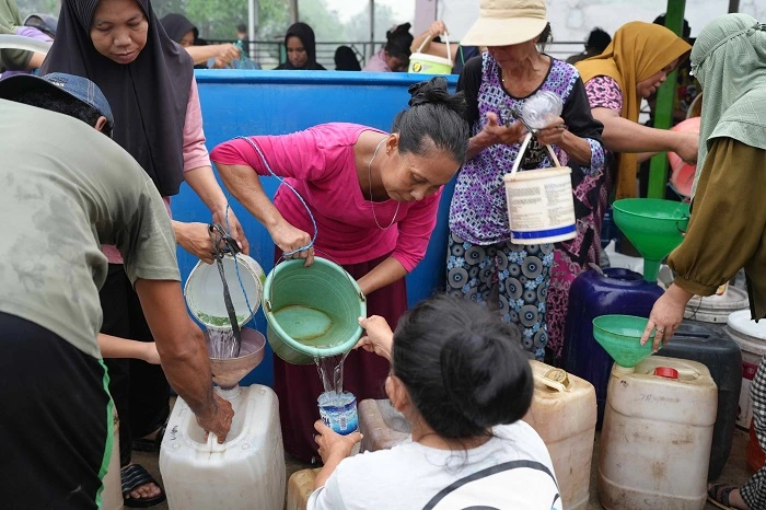 Warga Dusun Medan Jaya mengantri di tempat penyaluran air bersih oleh Kawasan Industri Pulau Penebang (KIPP) dan Badan Penanggulangan Bencana Daerah Kabupaten Kayong Utara, Kamis, (15/10/2026).