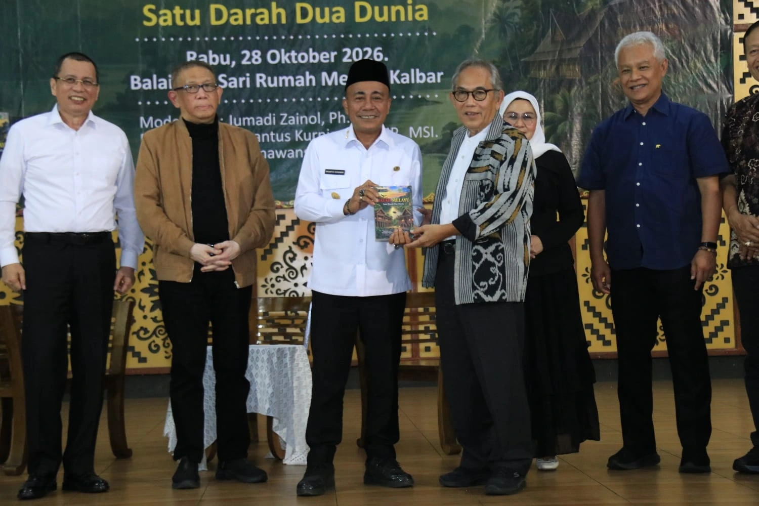 Ketua MABM Provinsi Kalbar Chairil Efendy saat menyerahkan buku Dayak-Melayu: Satu Darah, Dua Dunia di Rumah Adat Melayu, Rabu (28/10/2026)