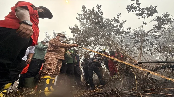 PADAMKAN - Gubernur Ria Norsan padamkan api saat meninjau langsung lokasi kebakaran hutan dan lahan (karhutla) di kawasan Sekunder C, Kecamatan Rasau Jaya, Kabupaten Kubu Raya, Rabu (2/9/2026).