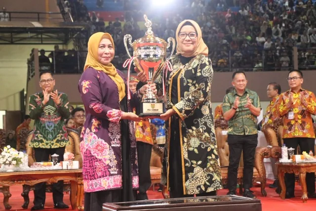 Pj. Bupati Pulang Pisau Hj Nunu Andriani saat menyerahkan piala bergilir kepada Pj Wali Kota Palangka Raya Hera Nugraha (Foto: Biro Adpim).