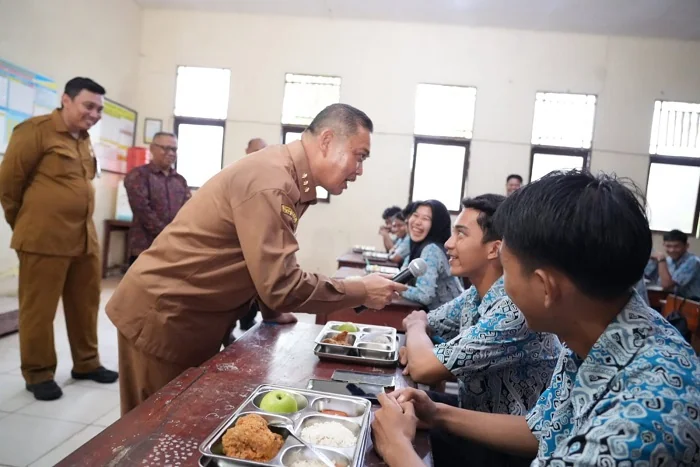 MAKAN BERGIZI - Gubernur Ria Norsan berinteraksi dengan siswa SMAN 1 Sungai saat menijau pelaksanaan Makan Bergizi Gratis (MBG) pada Selasa (25/11/2025)