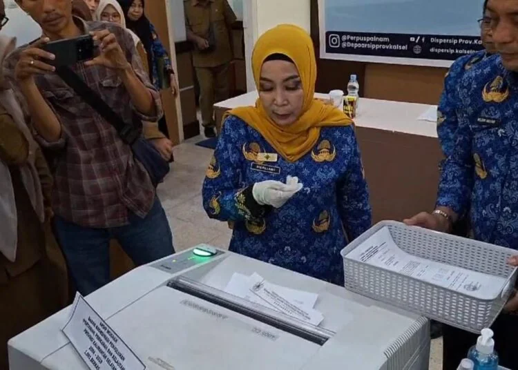 Kepala Dispersip Kalsel,Nurlianie Dadie saat memusnahkan arsip dari tiga SKPD di ruang lingkup Pemprov Kalsel (Poros Kalimantan)