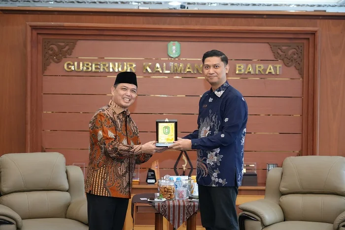AUDIENSI - Gubernur Ria Norsan memberikan cindremata kepada jajaran manajemen Garuda Indonesia dalam pertemuan strategis di Ruang Kerja Gubernur Kalbar, Jumat (9/1/2026).