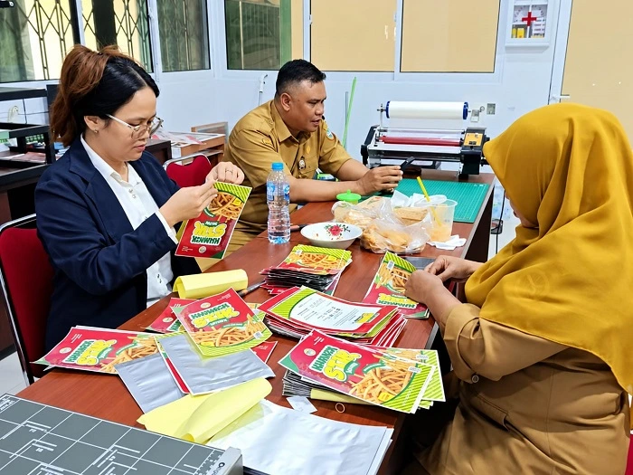 Petugas Rumah Kemasan yang berlokasi di Lantai 2 Pasar Kemuning tengah memproduksi kemasan untuk membantu pelaku UMKM