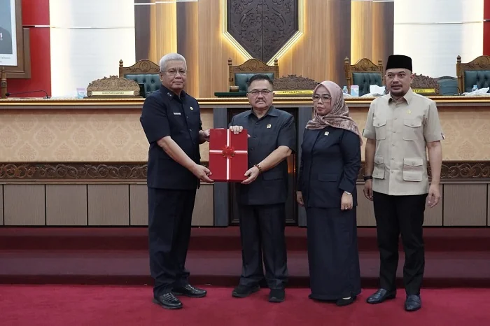 SERAHKAN - Sekda Provinsi Kalimantan Barat Harisson saat menyerahkan dokumen perubahan perda tentang pajak daerah kepada Ketua DPRD Provinsi Kalimantan Barat Aloysius di Balairungsari DPRD Provinsi Kalimantan Barat, Senin (27/7/2026)