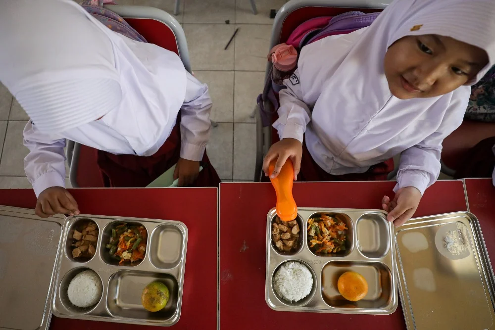 Murid di SDN Cilangkap 5, Depok, menikmati menu makanan pada Senin (6/1/2025), sebagai bagian dari peluncuran Program Makan Bergizi Gratis di 26 provinsi. (int)
