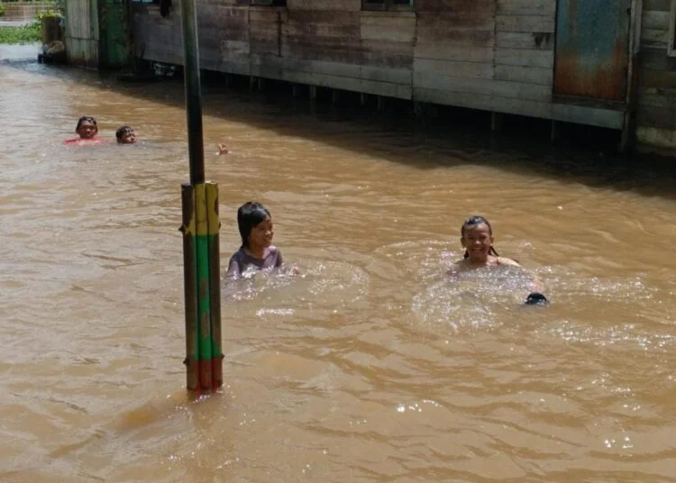 Anak- anak memanfaatkan banjir sebagai tempat bermain di kawasan SDN Pekauman 1 Martapura (Poros Kalimantan)